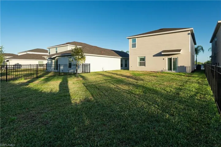 Rear view of house featuring a fenced backyard