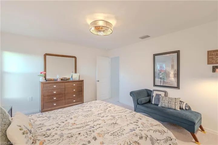Bedroom with light colored carpet and baseboards