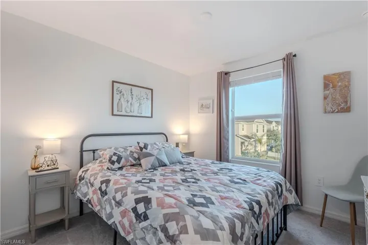 Bedroom featuring light colored carpet and baseboards