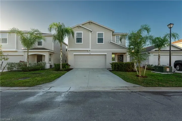Traditional-style home with a front lawn, concrete driveway, and a garage