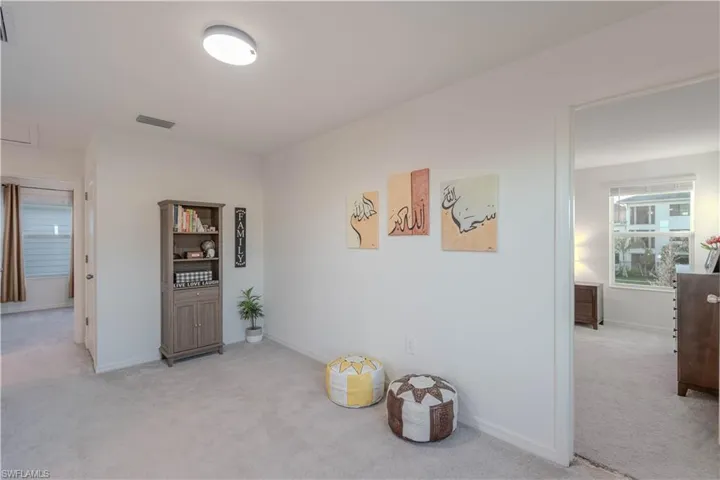 Hallway with light carpet and healthy amount of natural light