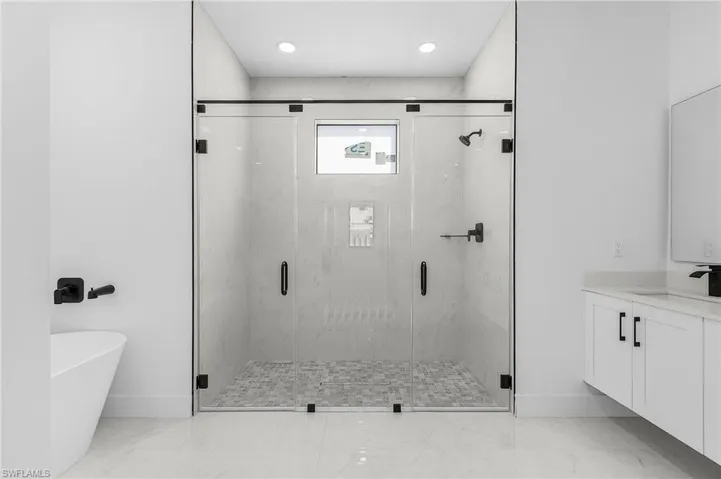 Full bathroom with a marble finish shower, vanity, a soaking tub, light marble finish flooring, and recessed lighting