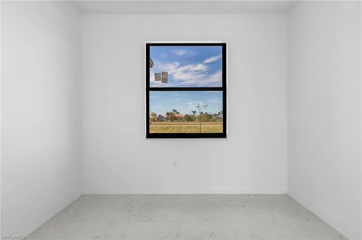 Empty room with baseboards and marble look tile flooring