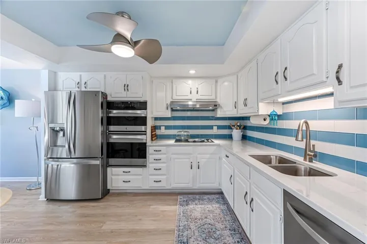 Fresh white cabinets with glass tile backsplash