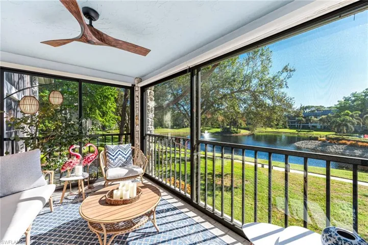 Sunroom / solarium with ceiling fan and a water view
