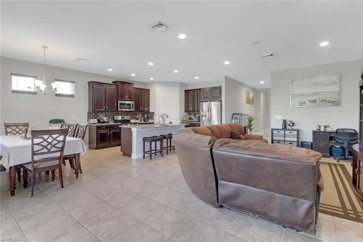 Living room with a chandelier, light tile patterned floors, visible vents, and recessed lighting