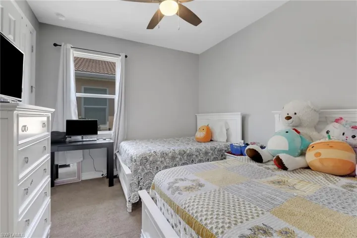 Bedroom featuring light colored carpet and a ceiling fan