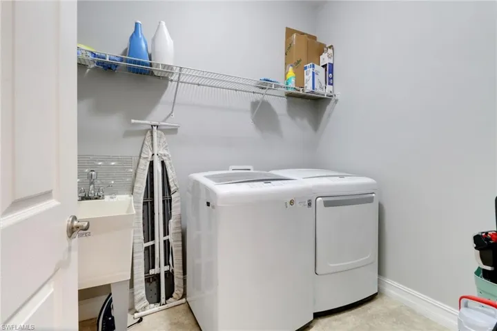 Washroom featuring baseboards, washing machine and dryer, and laundry area