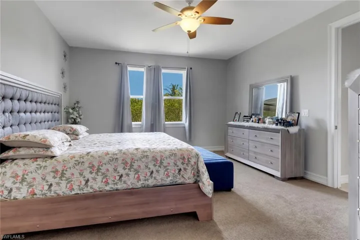 Bedroom with ceiling fan, carpet flooring, and baseboards