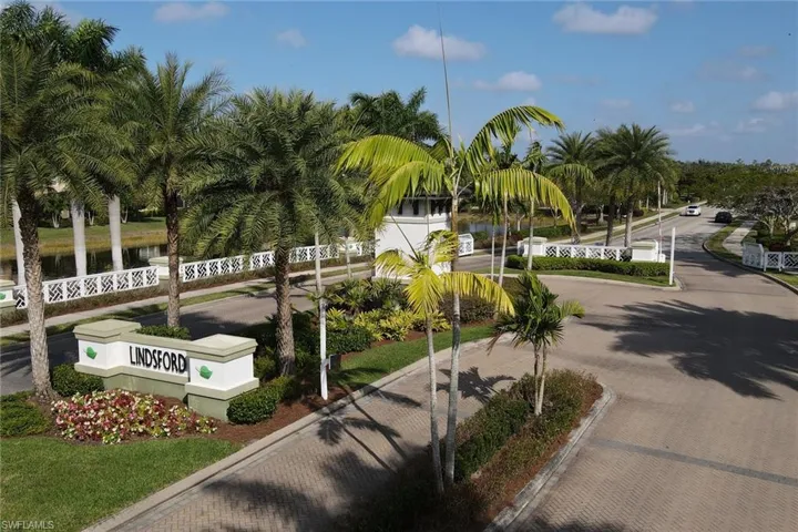 View of home's community with curved driveway, fence, and a water view