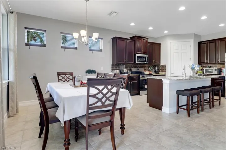 Dining space with a chandelier, recessed lighting, light tile patterned floors, and visible vents