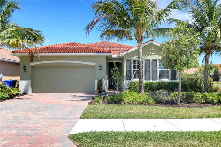 View of front of property featuring a tile roof, decorative driveway, a garage, and stucco siding