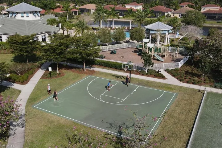 View of sport court with community basketball court, fence, playground community, and a lawn