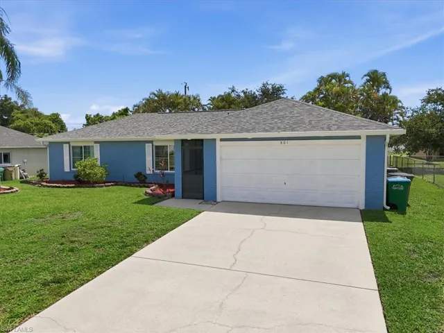 Florida-style residence featuring a blue exterior, white garage door, and a gray shingle roof