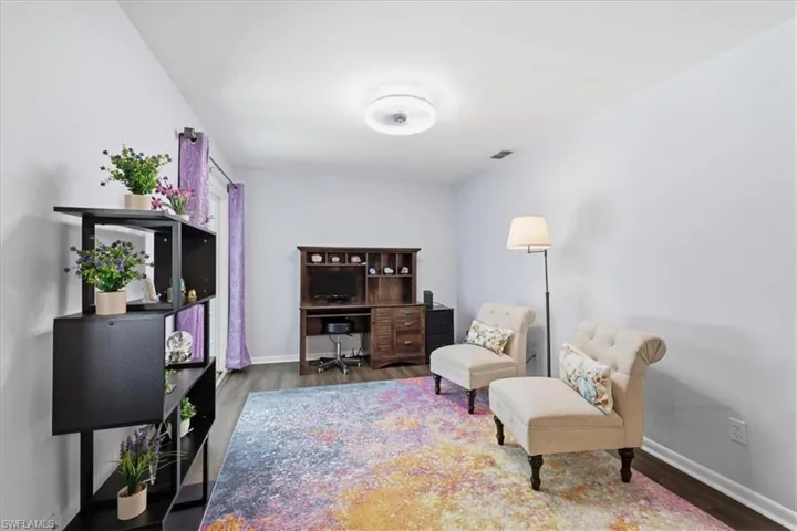 Neutral wall colors, wood-finish flooring, recessed ceiling lighting, and a window with curtain rod