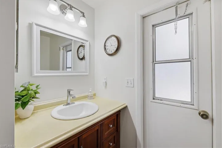 Bathroom vanity featuring a white oval sink, chrome faucet, and a light-toned countertop