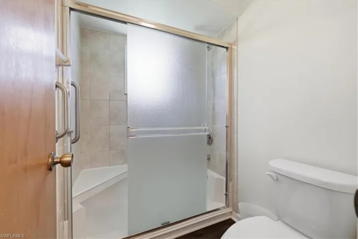 Shower enclosure featuring a frosted glass sliding door, brushed metal frame, and interior tile surround