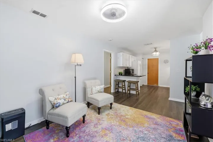 Open-concept living space featuring wood-finish flooring, recessed lighting, and a neutral wall color