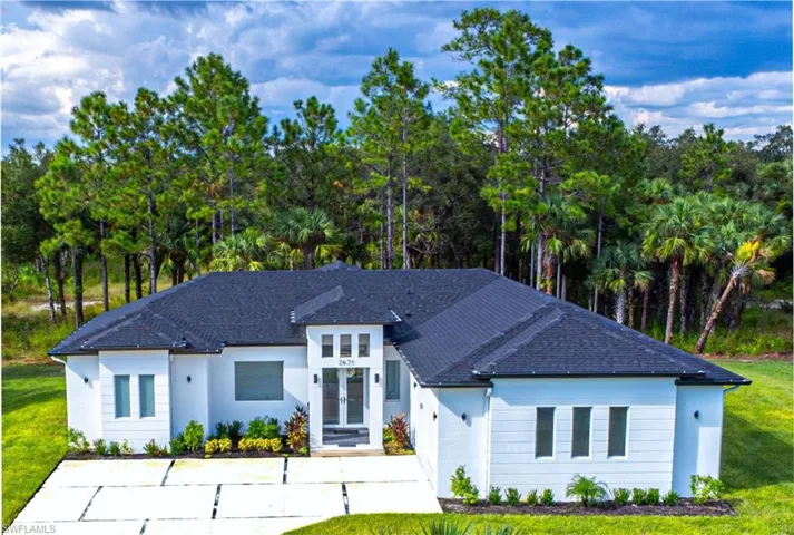View of front of home featuring french doors, stucco siding, and a front lawn