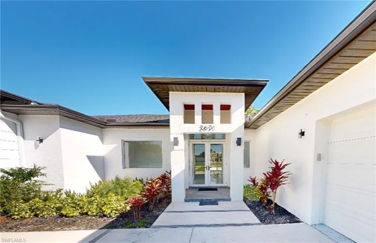 Property entrance featuring stucco siding and french doors