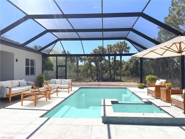 View of pool with a patio area, an outdoor living space, a pool with connected hot tub, and a lanai