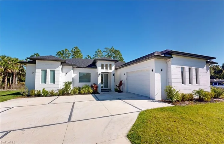 Prairie-style house with driveway, a garage, a front lawn, and stucco siding