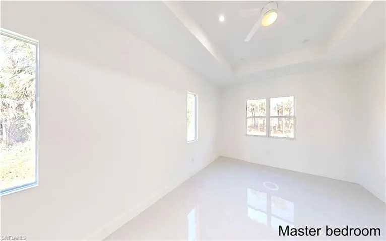 Unfurnished room featuring a tray ceiling, recessed lighting, and a ceiling fan