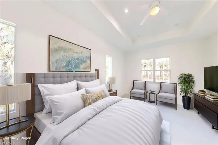 Bedroom featuring a raised ceiling, ceiling fan, carpet, and recessed lighting