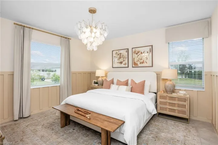 Board and batten wall treatment, decorative ceiling light fixture, two windows with blinds, wood-finish flooring