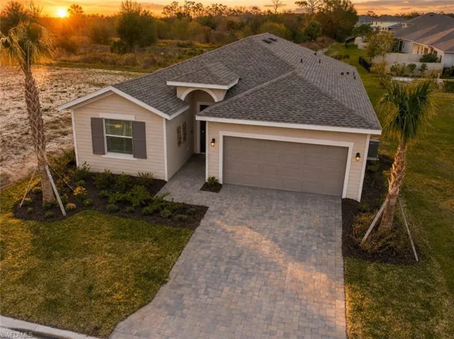 Contemporary residence with a paved driveway, two-car garage, and mature landscaping
