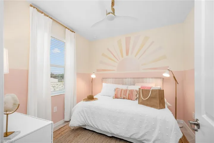 White paneled door, built-in ceiling fan, window with blinds, and decorative wall art