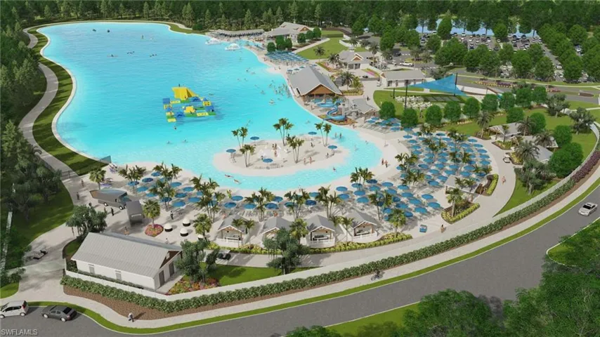 Expansive lagoon with a sandy beach, multiple cabanas, and shaded seating areas