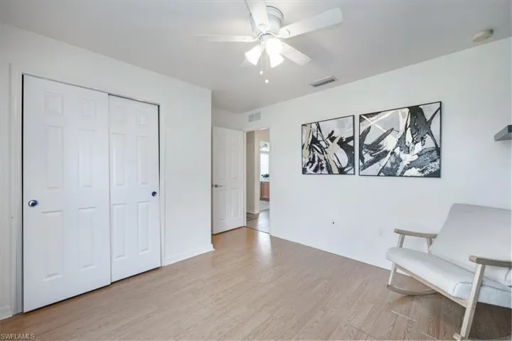 Sitting room with light wood-style flooring and ceiling fan