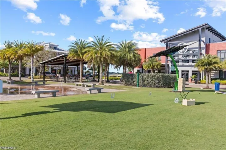 View of property's community featuring a lawn and a patio area