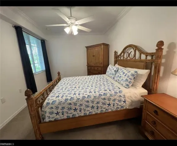 Bedroom featuring crown molding, ceiling fan, and dark carpet