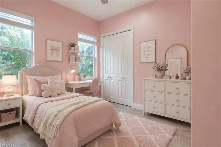 Virtually Staged - Spacious room featuring two large windows, light-tone wood-finish flooring, a ceiling fan, and white bifold closet doors