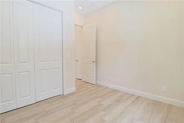 Interior room featuring light wood-finish flooring, white baseboards, and neutral wall paint