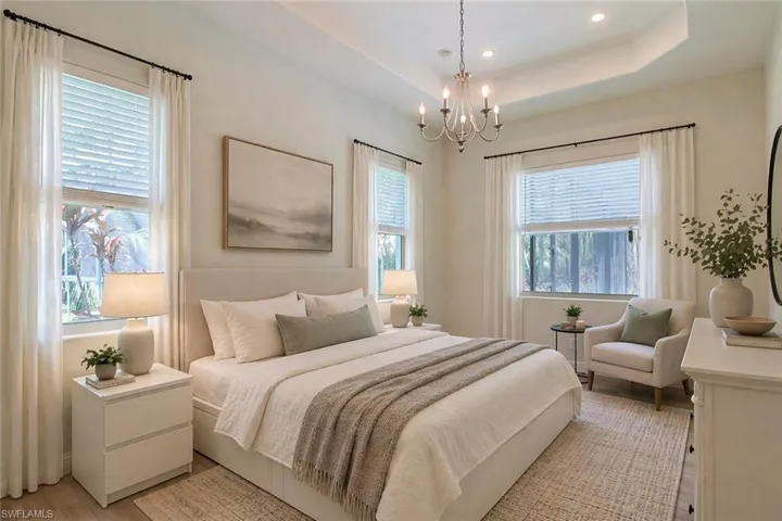 Virtually Staged - Bedroom featuring a tray ceiling, recessed lighting, and a chandelier