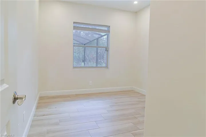 Room featuring light wood-finish flooring, recessed lighting, and a window with blinds