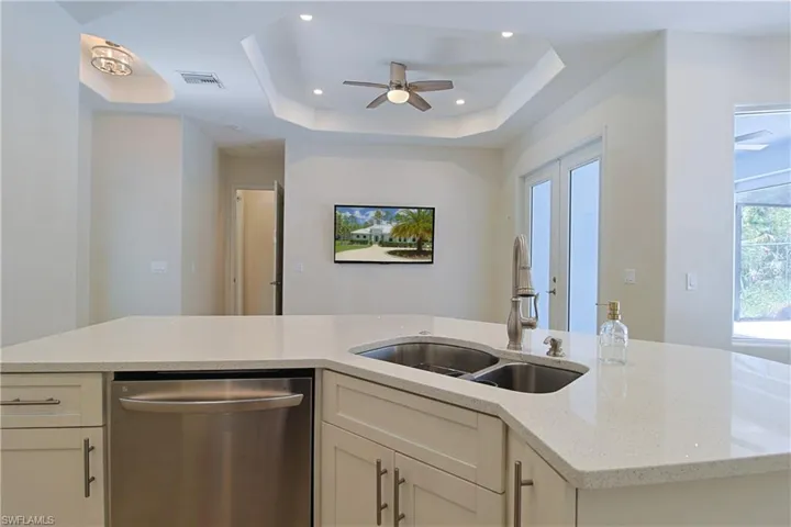 Kitchen island with light-toned countertop and dual stainless-steel sink