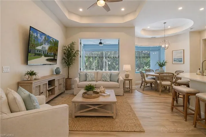 Virtually Staged - Open-concept living area featuring wood-finish flooring, recessed lighting, and a tray ceiling