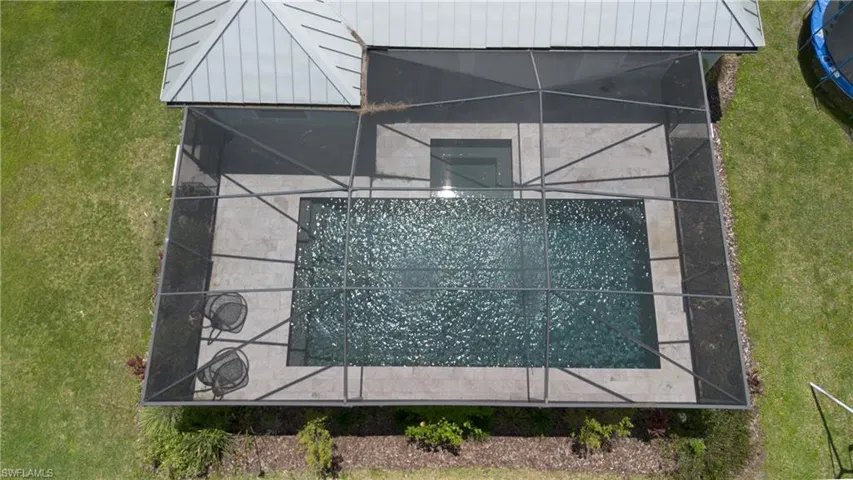 Screened enclosure surrounding an in-ground swimming pool and spa