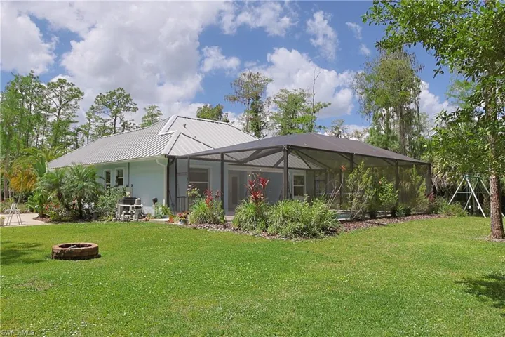 Expansive green lawn with a brick fire pit