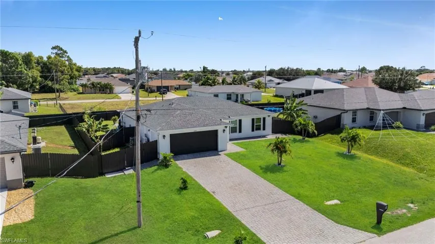Ranch-style home featuring a residential view, decorative driveway, and a garage