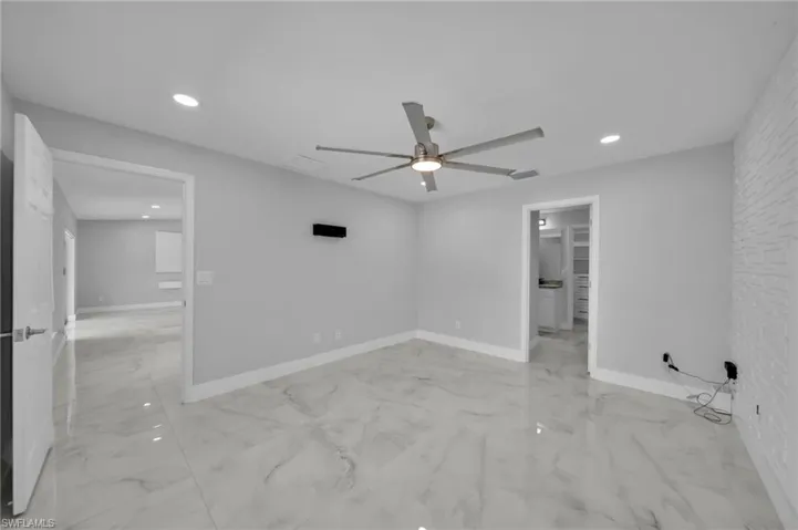 Unfurnished bedroom featuring recessed lighting, light marble finish flooring, and a ceiling fan