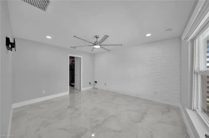 Spare room featuring light marble finish flooring, ceiling fan, and recessed lighting