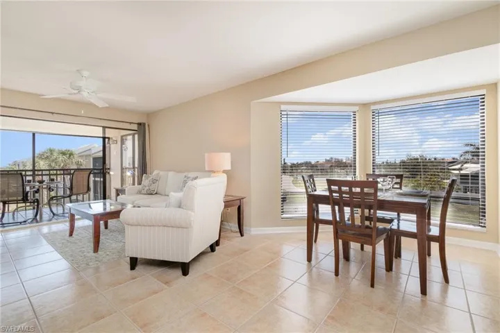 Dining/Living Space – Light tile flooring, ceiling fan, and views of the front pond.
