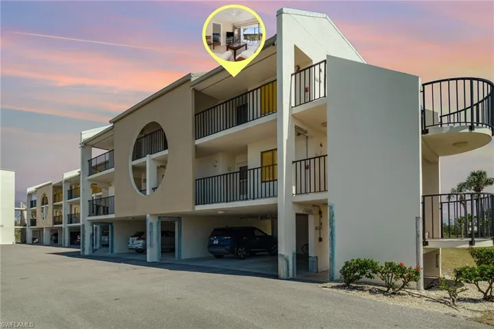 Property at dusk featuring covered parking