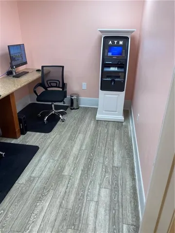 Office space with light hardwood / wood-style flooring and built in desk