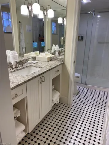 Bathroom featuring vanity, toilet, and an enclosed shower
